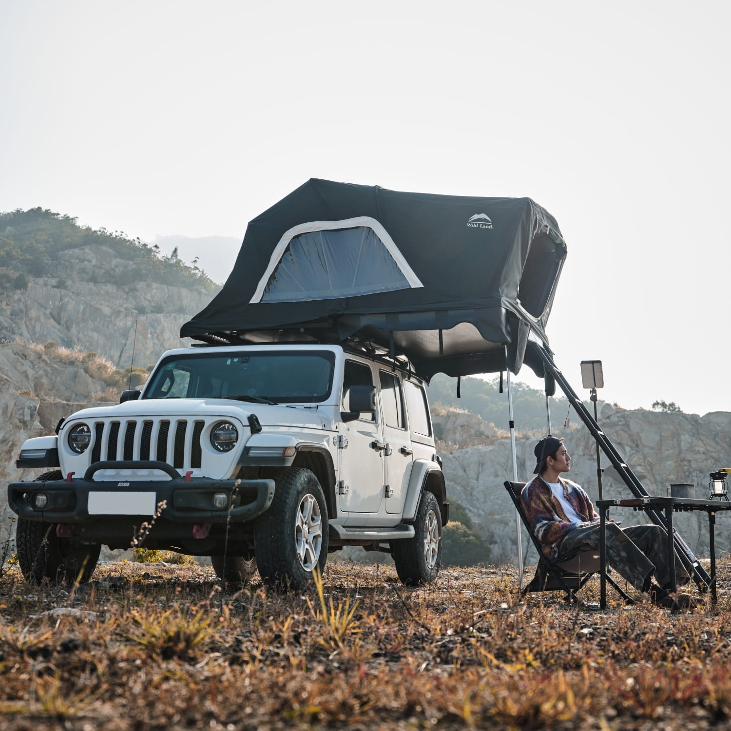namiot-dachowy-Wild-Land-Voyager-PRO-230-rozlozony-na-samochodzie-Jeep-Wrangler-zdjecie-z-rozlozonymi-meblami-przed-namiotem